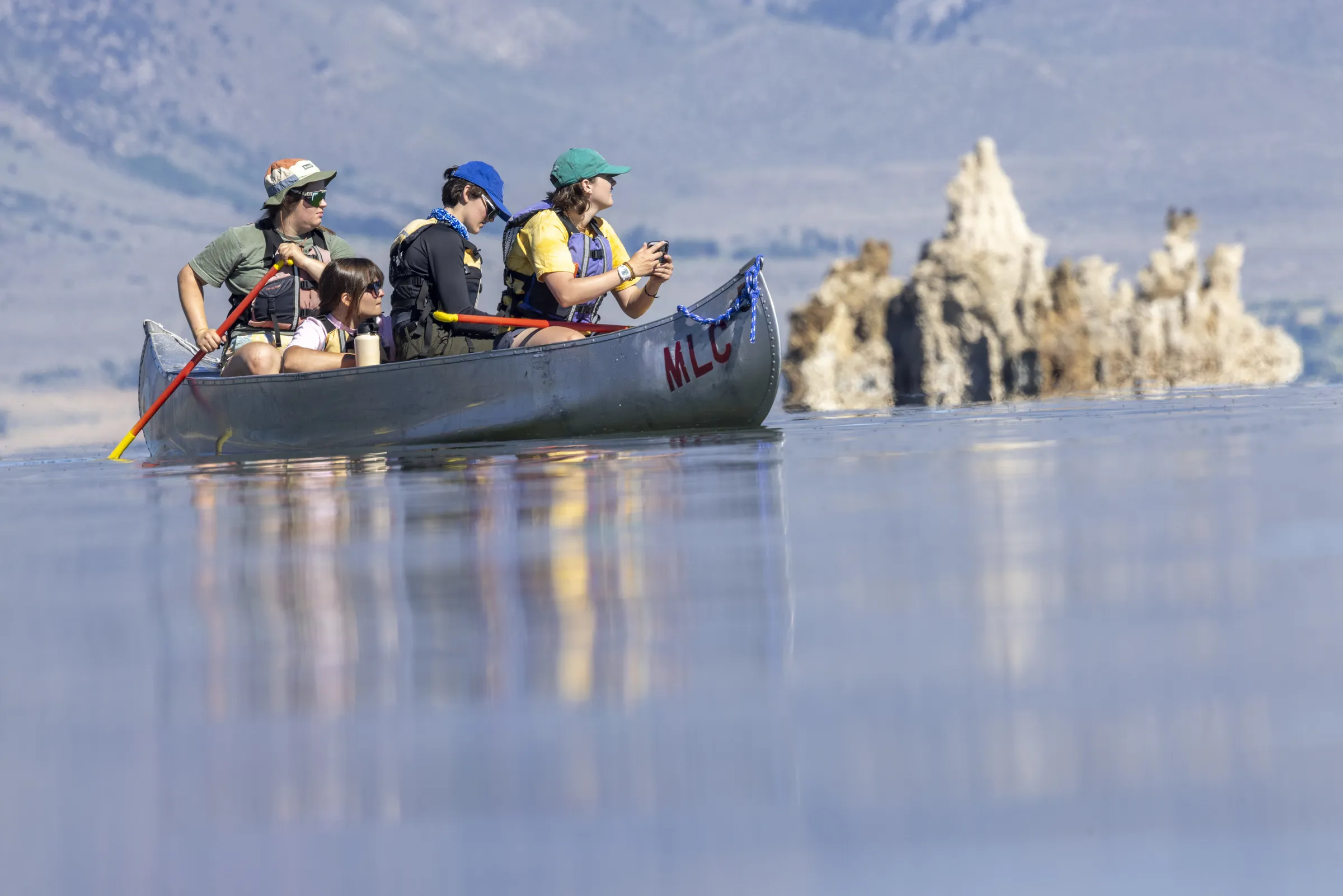 Four UGA students packed in a canoe surveying the waters.